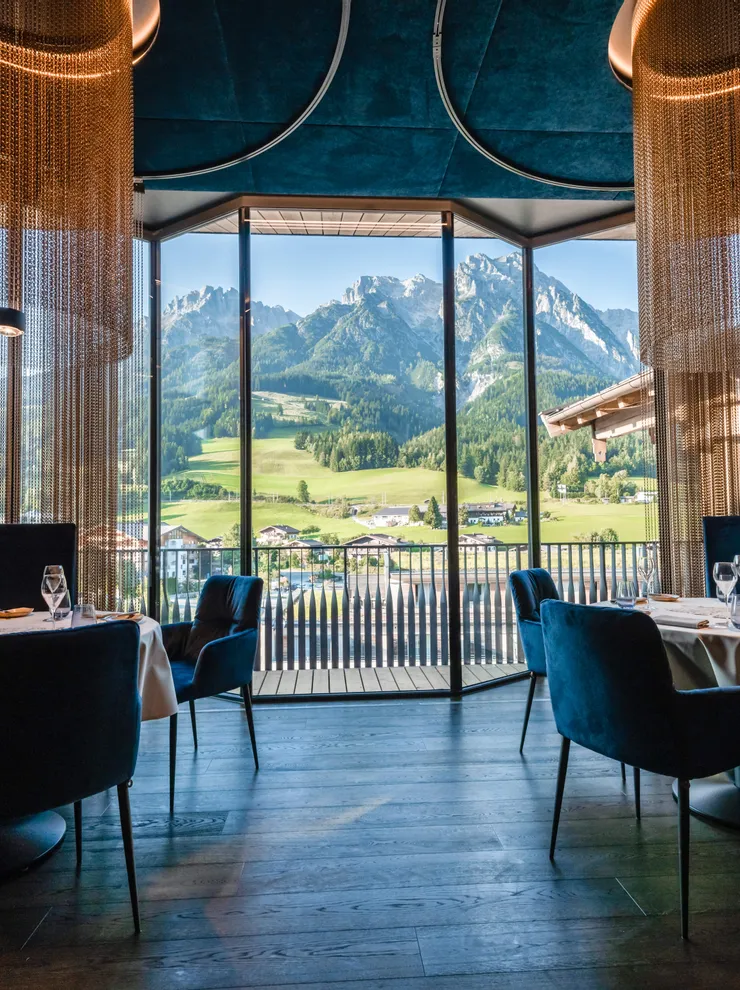 Elegant restaurant with mountain view through large window in alpine setting